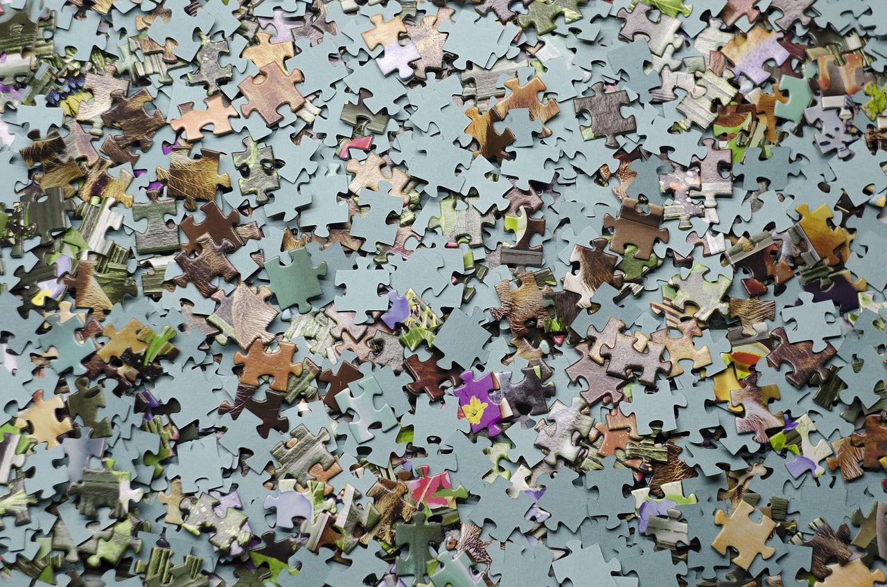 Close-up of colorful jigsaw puzzle pieces scattered on a table, perfect for family game night and puzzle enthusiasts.